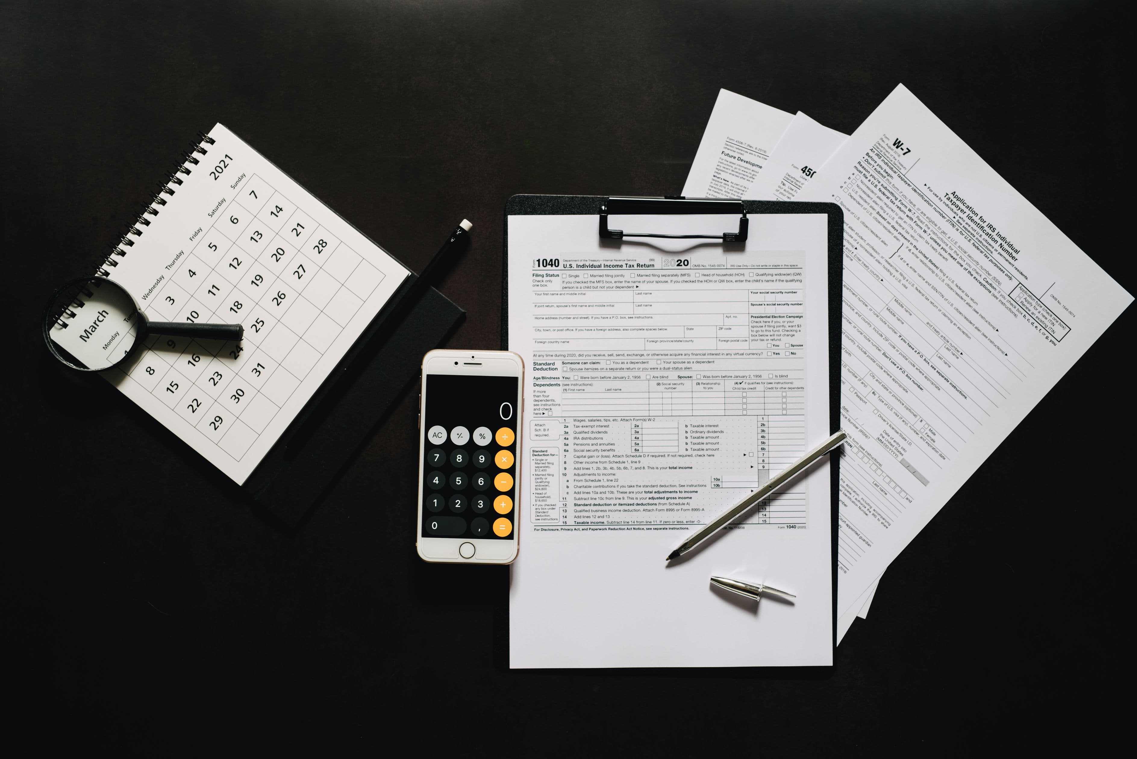 Flat lay of compliance forms, a calculator, and a calendar on a desk — representing the annual paperwork cycle behind EPA refrigerant reporting under 40 CFR Part 84 Subpart C